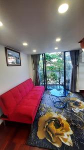 sala de estar con sofá rojo y mesa en Homestay Lucas's House, en Liên Trì (3)