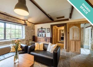 uma sala de estar com um sofá e uma mesa em Ventry Farm - Rainbow Cottage em Ventry