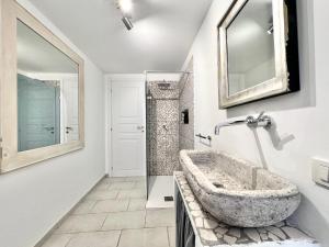 a bathroom with a stone sink and a mirror at ComeCasa 2 Bedrooms With Garden Apartment in Benevello