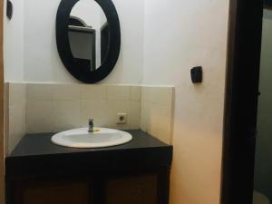 a bathroom with a sink and a mirror on the wall at Suastika Guest House in Ubud