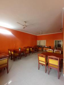 una sala da pranzo con tavoli e sedie in legno di Hotel Singhasan House a Jaipur