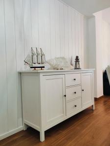 a white dresser in a room with white walls at Sea you soon apartment. Lloret de Mar city center in Lloret de Mar