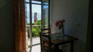 a table with a vase of flowers on a table with a window at Guest House Suga 1 in Qeparo