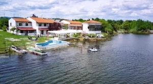 une maison sur un lac avec un bateau dans l'eau dans l'établissement Thrassa Hotel, à Tycherón