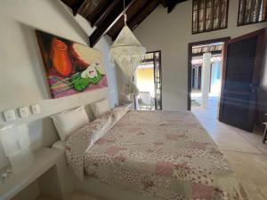 una camera da letto con un letto e un quadro sul muro di VILLA NACRI NA PRAIA con PISCINA ENTRE ILHEUS E ITACARE' a Ilhéus Altre 79 foto