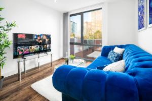 un sofá azul en la sala de estar con TV en Luxury Birmingham City Centre Apartment - Top Rated - 318H, en Birmingham