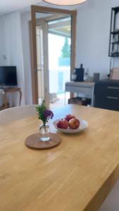 a plate of apples and a vase of flowers on a table at Haus Olga in Hörbranz