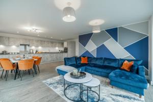 a living room with a blue couch and a table at Penthouse-Central-Free parking in Buckinghamshire