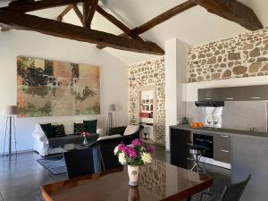 cocina y sala de estar con mesa en Les Hauts de CLuny, en Cluny