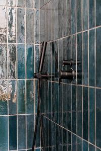 a shower in a bathroom with blue tiles at Boho Chic Studio Stellenbosch in Stellenbosch