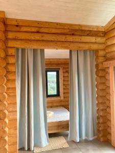 a room with a window and curtains in a log cabin at Mountain Log Cabin O Lobo in Cabeceiras de Basto