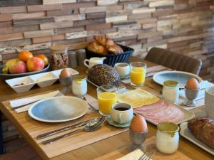 einem Holztisch mit Frühstückszutaten und Eiern darauf in der Unterkunft FORMOSA DIJON in Étaules