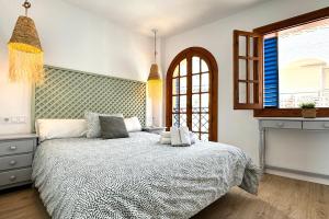 a bedroom with a bed and a window at Apartamentos Vela Blanca in San José