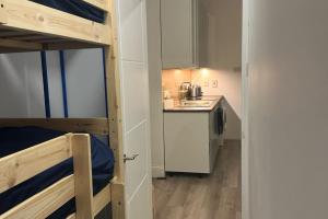 a small room with a kitchen and a bunk bed at Wimbledon 2 Bed Tennis & Travel in London