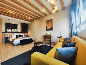 ein Hotelzimmer mit einem Bett und einem Sofa in der Unterkunft FORMOSA DIJON in Étaules