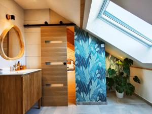 ein Badezimmer mit einem Waschbecken und eine Tür mit einer Pflanze in der Unterkunft FORMOSA DIJON in Étaules