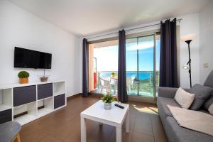 a living room with a couch and a view of the ocean at Homeincalpe Borumbot in Calpe