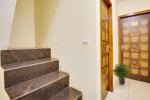 a staircase in a room with a door and a plant at OYO Flagship 80943B Hotel Blue Shine in Ludhiana