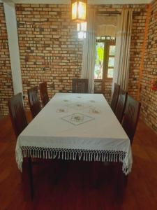 une salle à manger avec une table et des chaises blanches dans l'établissement Mellows Home, à Horana
