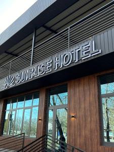 a sun rise hotel sign on the side of a building at Sunrise Hotel in Taldykorgan