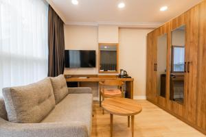 a living room with a couch and a desk at EÖB TAKSİM HOTEL in Trabzon