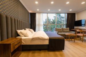 een slaapkamer met een bed, een bureau en een televisie bij EÖB TAKSİM HOTEL in Trabzon
