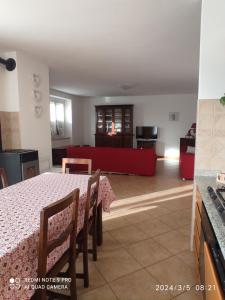 uma sala de jantar com uma mesa e um sofá vermelho em Casa "La Forcella" em Brembilla