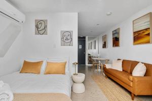 a bedroom with a bed and a couch and a table at Modern Studio Retreat in Crown St with AirCon in Sydney