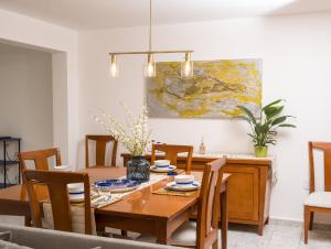 een eetkamer met een houten tafel en een schilderij bij Casa Alegria in Miravalle