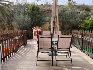 eine Terrasse mit einem Tisch, Stühlen und einem Sonnenschirm in der Unterkunft Be Room Oasis Harmony in Maspalomas