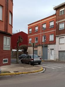 蓬費拉達的住宿－Tu Apartamento Ideal，两辆汽车停在大楼前的停车场