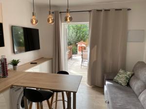 eine Küche und ein Wohnzimmer mit einem Tisch und einem Sofa in der Unterkunft Be Room Oasis Harmony in Maspalomas