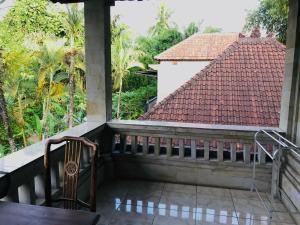 a balcony with a view of a house at Suastika Guest House in Ubud