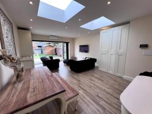 a living room with couches and a table and skylights at South Park in Seven Kings