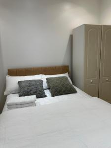 ein Schlafzimmer mit einem weißen Bett mit zwei Kissen in der Unterkunft Beautiful Double Room with Free Wi-Fi and free parking in Lewisham