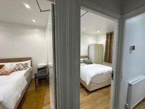 ein kleines Schlafzimmer mit 2 Betten und einem Spiegel in der Unterkunft Beautiful Double Room with Free Wi-Fi and free parking in Lewisham