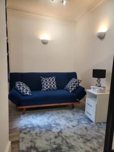 a blue couch in a living room with pillows at 2bed2 bath flat soho in London