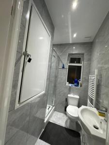y baño con aseo, lavabo y ducha. en Beautiful Double Room with Free Wi-Fi and free parking en Lewisham