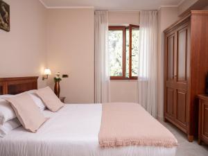 1 dormitorio con cama blanca y ventana en Hotel SAN PIO, en San Giovanni Rotondo