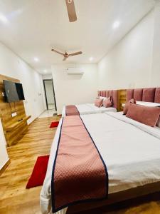 a bedroom with two beds and a flat screen tv at HOTEL D.S in Amritsar