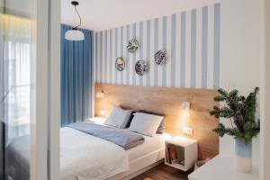 1 dormitorio con 1 cama con rayas azules y blancas en I Love Gdynia Apartments - apartament z parkingiem en Gdynia