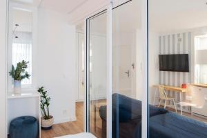 格地尼亞的住宿－I Love Gdynia Apartments - apartament z parkingiem，客厅设有玻璃墙和蓝色沙发