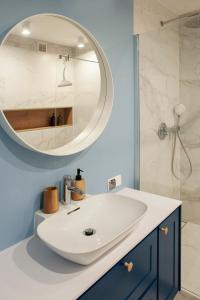 uma casa de banho com um lavatório branco e um espelho. em I Love Gdynia Apartments - apartament z parkingiem em Gdynia