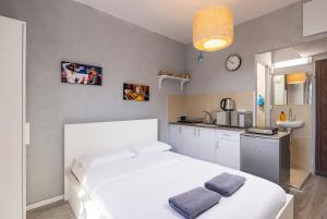 1 dormitorio con 2 camas blancas y cocina en Ran's Cozy Hotel Style apt en Tel Aviv
