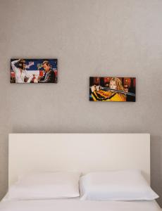 tres fotos colgando en una pared sobre una cama en Ran's Cozy Hotel Style apt en Tel Aviv