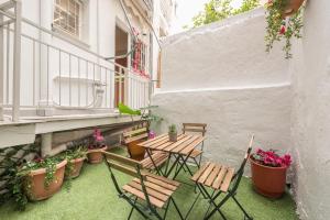 un patio avec des chaises, des tables et des plantes en pot dans l'établissement Golden Comfort By Greece Apartments, à Athènes