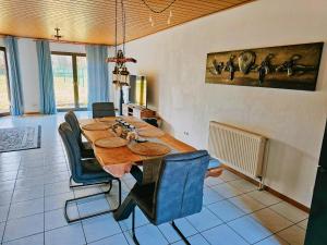 a dining room with a wooden table and chairs at Pimp My TLA-Ramstein House in Ramstein-Miesenbach