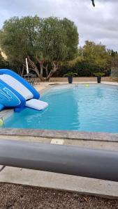 uma piscina azul com um escorrega no meio em Le 7 em Servian