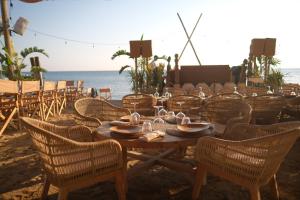a wooden table and chairs on the beach at @before sunset in Çeşme