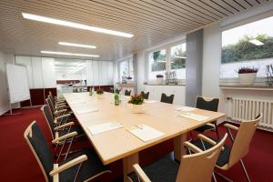 a large conference room with a long table and chairs at IN VIA Hotel in Paderborn